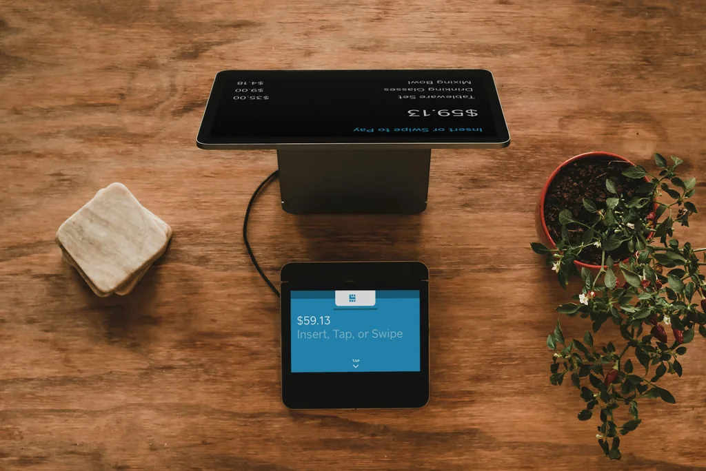 Payment terminal and till screen on a wooden surface