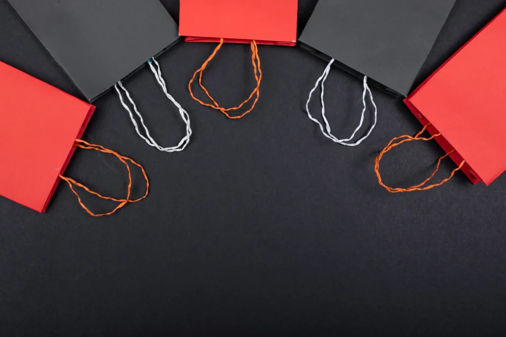 Red and black paper bags on a dark surface